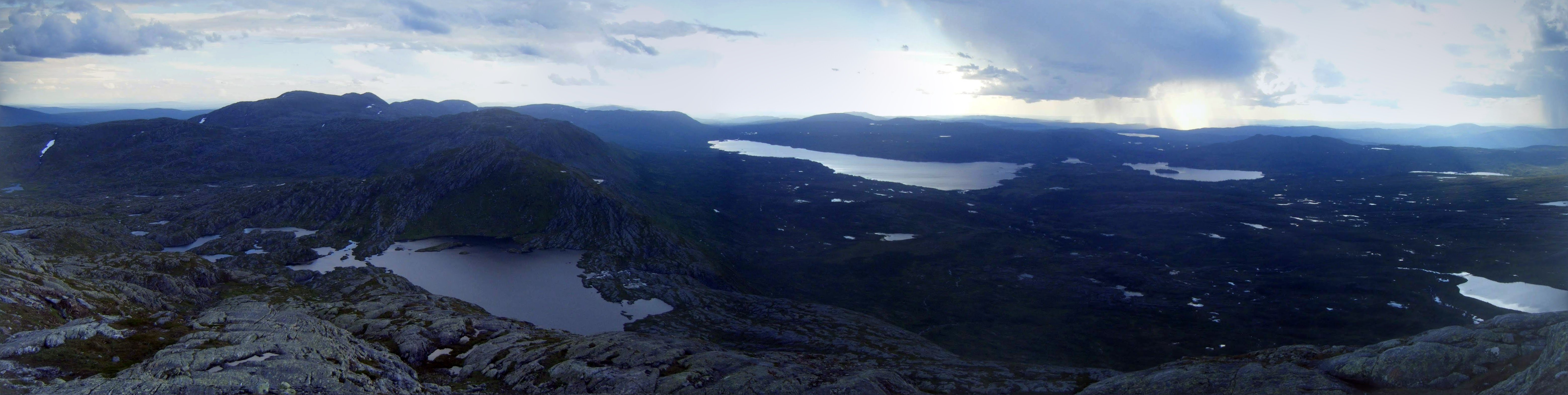 Skjaekerhatten - view over Skjaekervatnet, with view of Lustadvatnet in the distance under a raincloud.